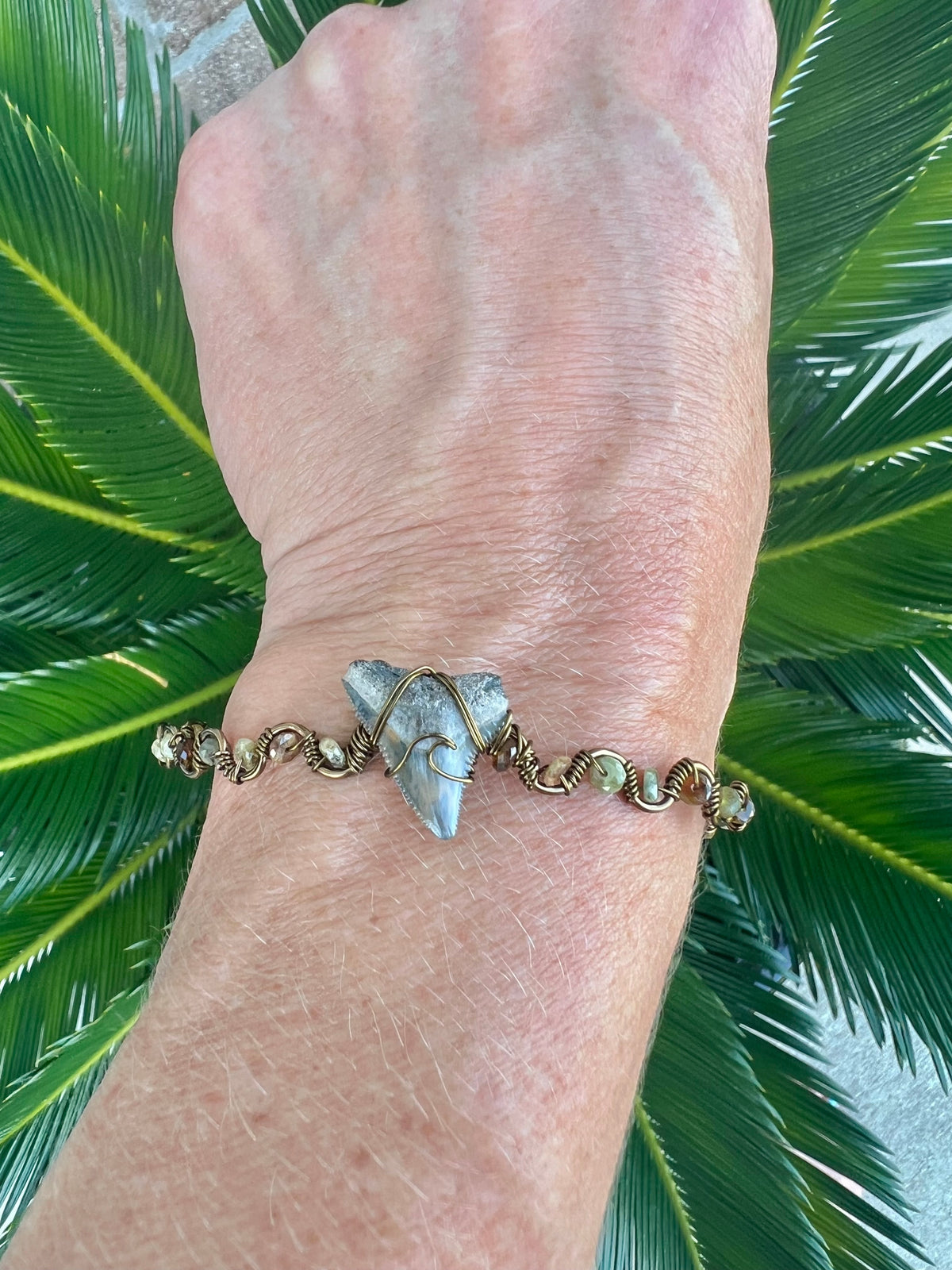 Shark tooth with green garnet gemstones, and bronze cuff bracelet
