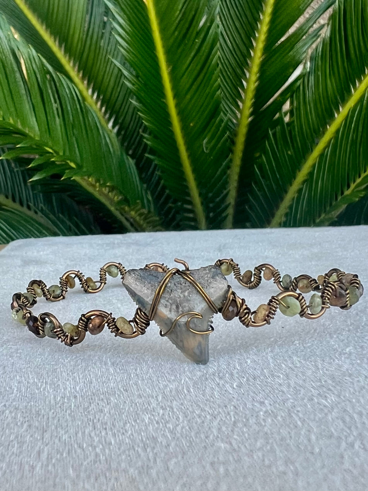 Shark tooth with green garnet gemstones, and bronze cuff bracelet